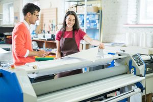 man and woman in front of wide format color proofer