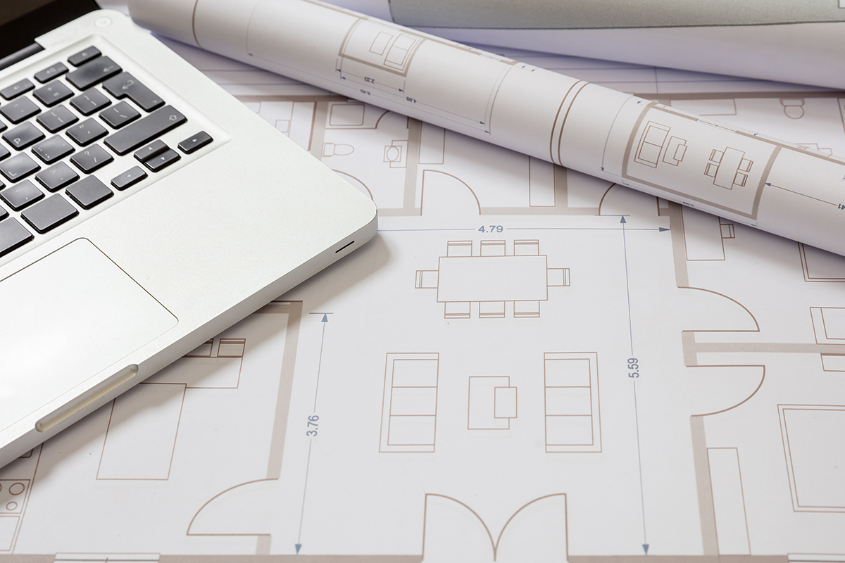 laptop computer on top of cad plans